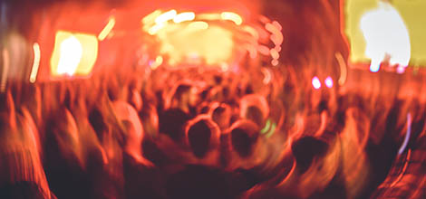 Blurred image of concert crowd during festival, hands up of many people and drugs effect